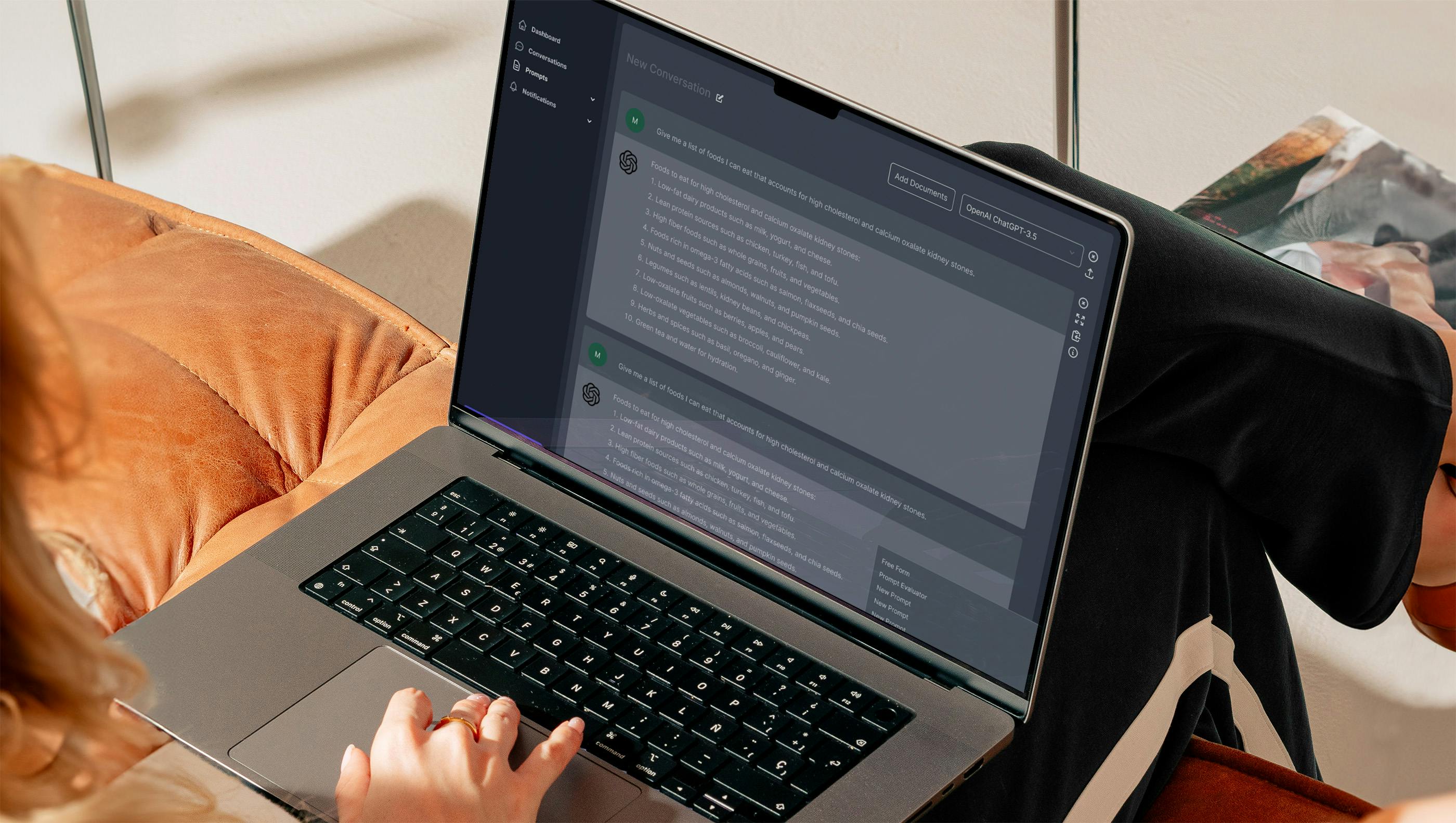 A person at a laptop with their hand on the trackpad looking a screen.